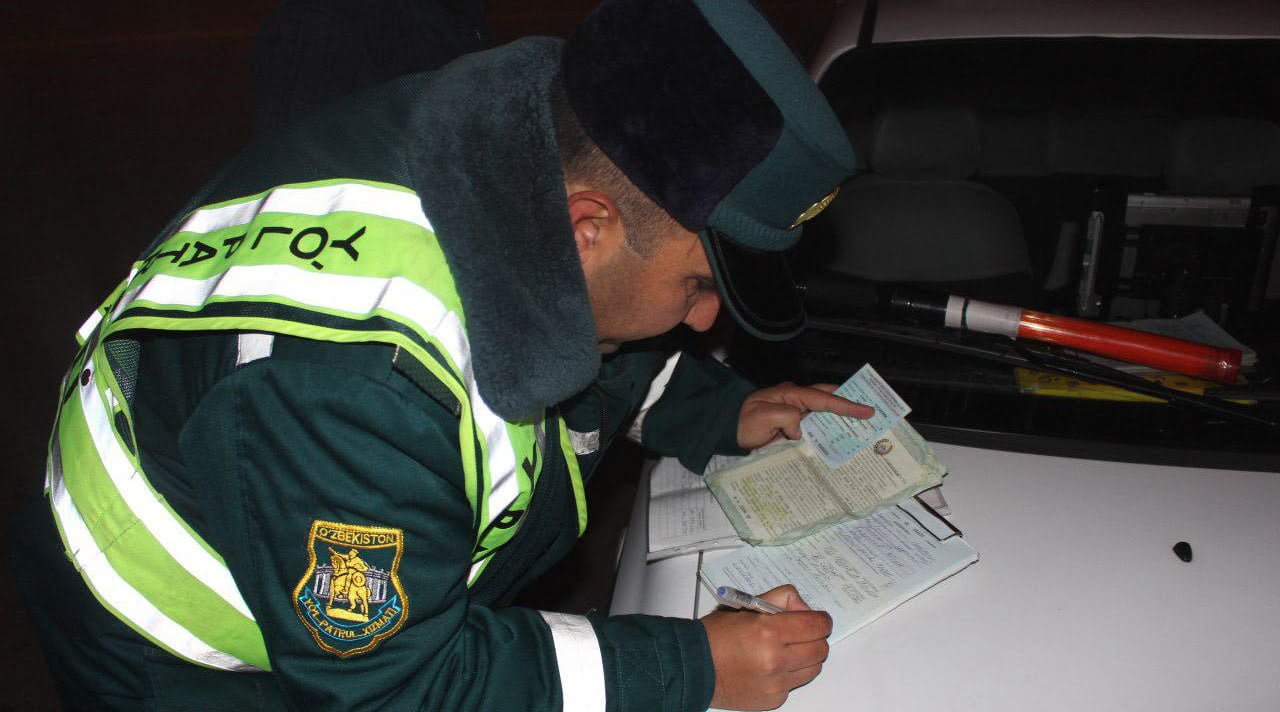 Инспектор ДПС ГАИ оформляет протокол об административном правонарушении в Ташкенте, Узбекистан