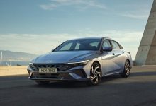Dengiz boʻyidagi kumushrang Hyundai Elantra sedani, old va yon tomondan koʻrinish