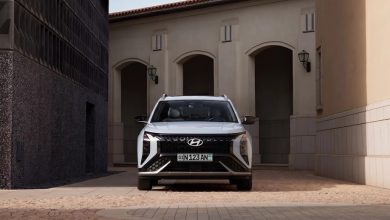 Белый Hyundai Mufasa у здания с арками, вид спереди