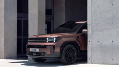 Hyundai Santa Fe медного цвета у бетонной стены, вид спереди-сбоку