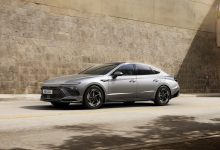 Серая Hyundai Sonata на улице у каменной стены, вид спереди-сбоку