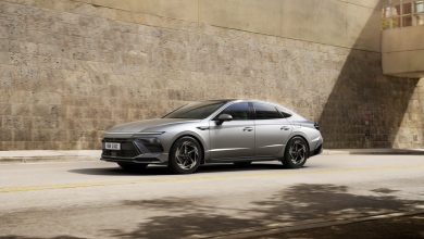 Серая Hyundai Sonata на улице у каменной стены, вид спереди-сбоку