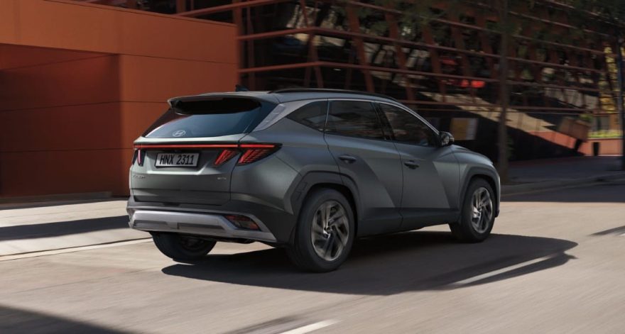 Hyundai Tucson в Узбекистане: цены, комплектации и характеристики - 2 Серый Hyundai Tucson в движении по городской улице, вид сзади-сбоку