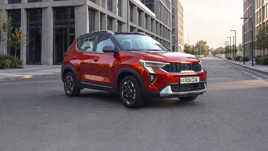 Kia Sonet в рассрочку без процентов: взнос и ежемесячный платеж - 2 Красный Kia Sonet Prime спереди сбоку на пустой улице между офисными зданиями